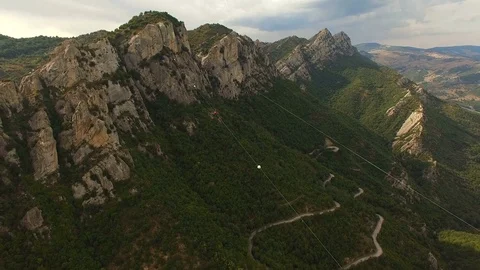 Aerial. People flies between two mountain peaks over a stunning valley Stock Footage 71745364