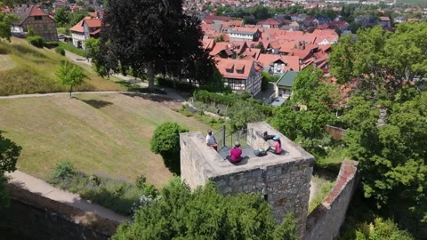 Aerial of people at a stone wall viewpoint above Blankenburg rooftops 動画素材 337979110
