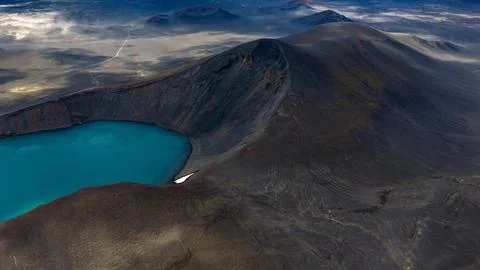 Aerial perspective of active volcanic cone with bright turquoise crater lake  Stock Photos