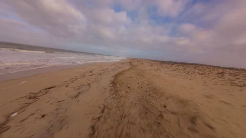 Aerial perspective of beach with waves and cloudy skies Video stock 345149443