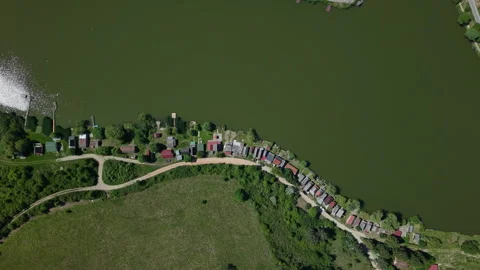 An aerial perspective captures a series of small holiday cottages situated Vídeos de archivo 336707397