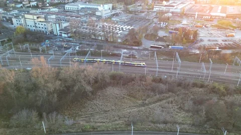 Aerial perspective captures a vibrant train traveling along railway tracks Video stock 330051565