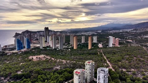 Aerial Perspective Capturing Towering Buildings Along Wooded Coastlines During Stock Footage 323561844