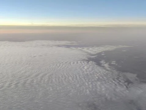 Aerial perspective capturing tranquil ocean and layered clouds at sunrise i.. Photos