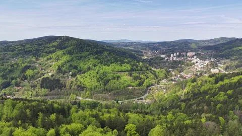 Aerial perspective capturing valley settlement surrounded by lush trees and.. Stockfoto's