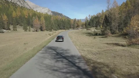 Aerial perspective of a drone flying over the Alps and over a car Stock Footage 135163213