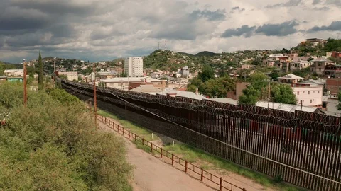 Aerial Perspective Elevating up over the Border Wall at Nogales Arizona Stock Footage 115058445