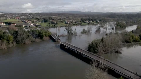 Aerial perspective frames the broken crossing within the wider flooded valley 動画素材 328735937