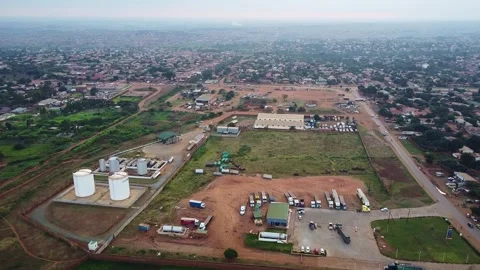 An aerial perspective of an industrial complex with storage tanks, vehicles, and Vídeos de archivo 316948994