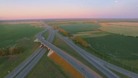 Aerial perspective of interstate commuter traffic crossing bridge on clear Stock Footage 77490460