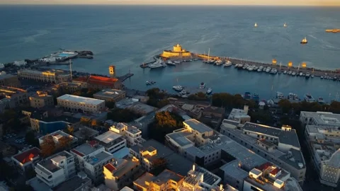 Aerial perspective of lighthouse from pier with small fleet of tourist boats Stock Footage 218234387