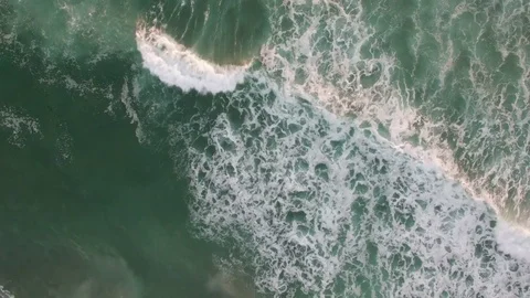 An aerial perspective looking straight down at the ocean with waves rolling in. 库存影片 75694920