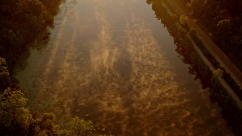Aerial perspective of a misty and dramatic summer sunrise over the Huron River Stock Footage 294152419