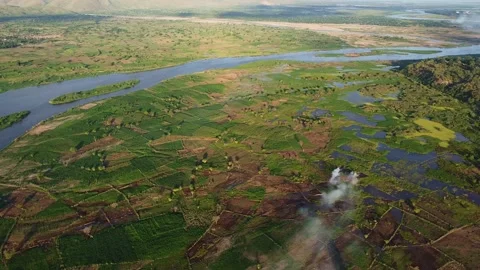 Aerial perspective of the nile river flowing through a verdant landscape with Stock Footage 316950656