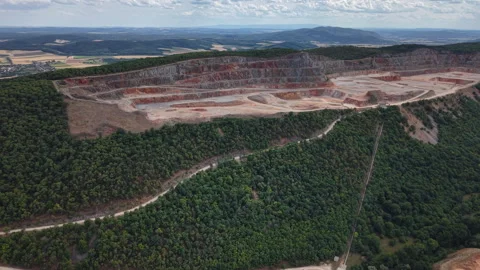 An aerial perspective of an open-pit quarry showing tiered excavation levels Stock Footage 340897416
