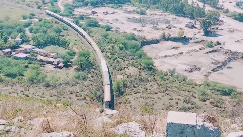 Aerial perspective of passenger train entering mountain railway tunnel 库存影片 333542704