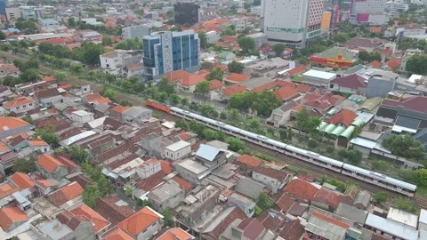 Aerial Perspective of a Passenger Train on Tracks Surrounded by Urban Housing Vídeo Stock 334764605