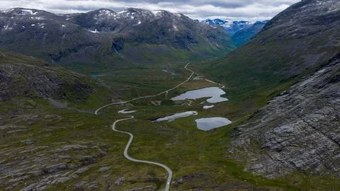 Aerial perspective of Rauma valley showing serpentine mountain road, multiple Stock Photos