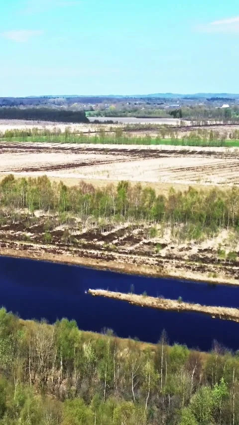 Aerial perspective revealing a blue artificial lake next to a spring forest and Stock Footage 346000205