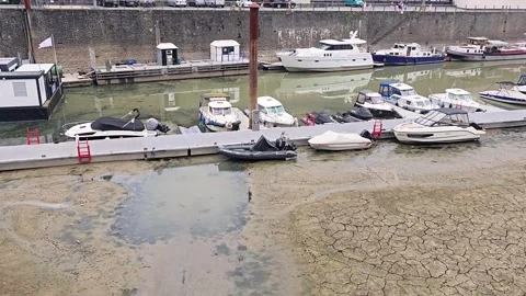 Aerial perspective of river harbor with dried muddy ground and grounded boats Stock Footage 345684885