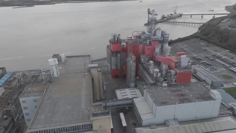 Aerial perspective of riverside chemical processing complex with red silos Stock Footage 310597256