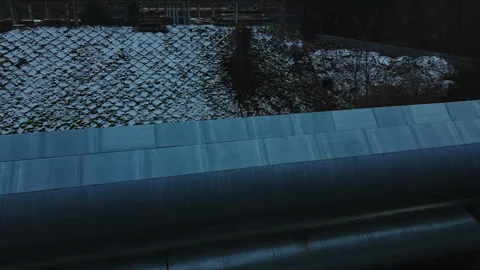 Aerial perspective showcasing twin pipelines navigating snowy terrain amid Stock Footage 325348769