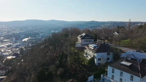 Aerial perspective of Stuttgart showcasing residential houses surrounded by lush Stock Footage 304886193