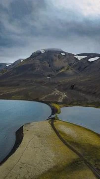 Aerial perspective of volcanic mountain with patchy snow coverage overlooking Stock Photos