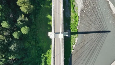 Aerial photography of a cable-stayed bridge in a mountain gorge with a green Vidéo 145575381