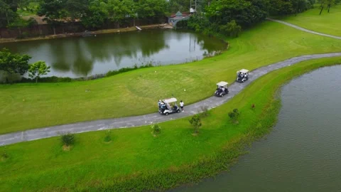 Aerial photography of a golf course with players and a golf cart Video stock 242408853