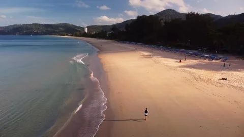 Aerial phuket beach lone runner is sprinting along shoreline during sunrise Stock Footage 344085996