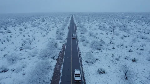 Aerial of pickup trucks heading down a rural highway in winter Stock Footage 234553386