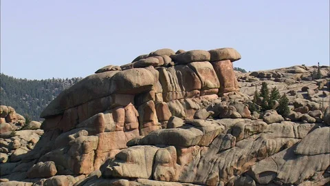 Aerial of piled rock structure surrounded with forest trees, Main Clump Of Stock Footage 109470712
