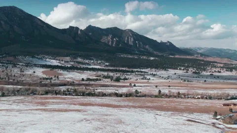 Aerial: Pine trees on snow covered hills and mountain range. Boulder, Colorado, Stock Footage 161053997