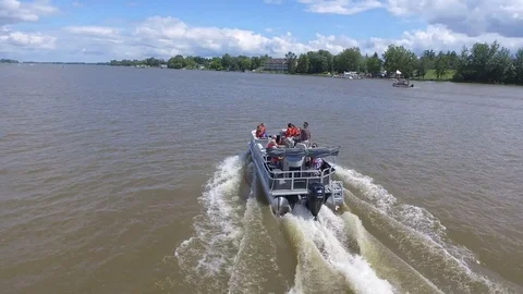 Aerial pontoon boat full of people waving to camera 4k Stock Footage
