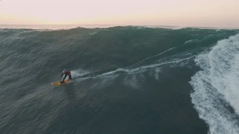 Aerial of pro surfer getting speed with help of jet ski to surf big ocean waves Stock Footage 159843071