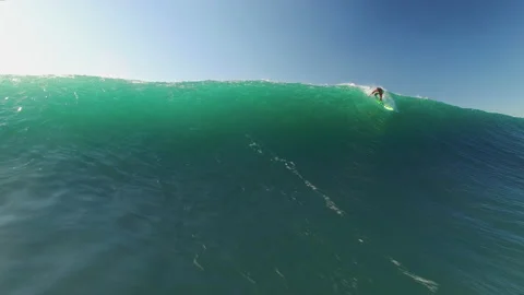 Aerial of pro surfer taking advantage of huge ocean wave and surfing it down Stock Footage 160744692