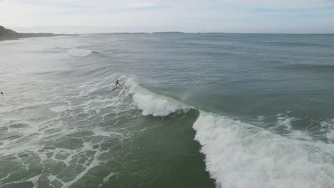 Aerial of pro surfers from Red Chargers riding waves in ocean on warm day Stock Footage 157112853