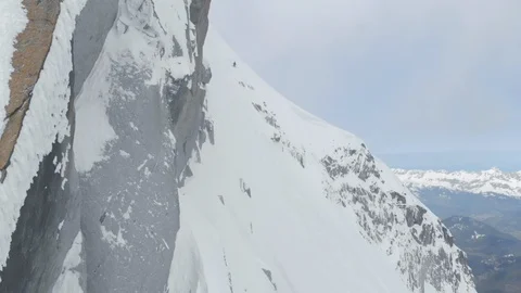 Aerial of professional skier going down snowy side of mountain in zigzag motion Stock Footage 121595814