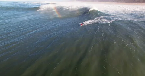 Aerial of professional surfer using jet ski and carrying another surfer on board Stock Footage 155795501