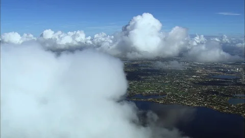 Aerial of puffy white clouds over lake and green coastal landscape, Cloud level Stock Footage 109143578