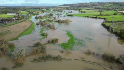 Aerial Pull in and Lower over flooded fields in Lacock Stock Footage 254785542