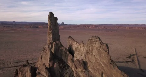 Aerial pull away from jagged spooky rock formation in the desert evening. Stock Footage 99565959