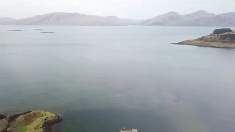 Aerial pull away reveal of the beautiful and historical Castle Stalker, Stock Footage 101591931