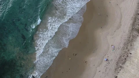 Aerial pull away of turquoise blue waves rolling onto shore Stock Footage 157229569