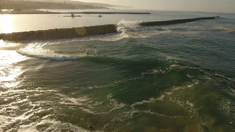 Aerial pull away of waves crashing onto the shore on a sunny morning Stock Footage 157129116