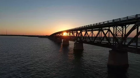 AERIAL: Pull back and rise up over an old bridge in the middle of the Stock Footage 98673172