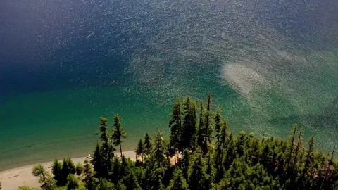Aerial pull back of blue water lake surrounded by mountains 库存影片 209343848