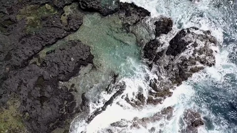 Aerial Pull Back Of Coast Line With Waves Crashing Over Black Rocks Vídeo Stock 78076281