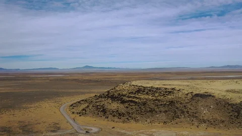 Aerial-Pull back from desert view to volcanic rock formation Stock Footage 120816268